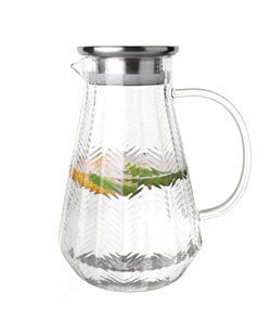 A clear glass pitcher with a textured pattern contains water infused with lemon and green leaves. Description generated by AI