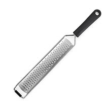 A long, narrow stainless steel grater with a black handle and a hole for hanging. Description generated by AI