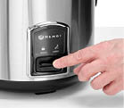 A person is pressing a button on a stainless steel Hendi appliance, likely a food warmer or cooker. Description generated by AI